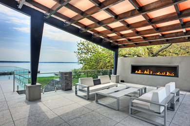 Photo of a medium sized contemporary back patio in New York with a gazebo and a fireplace.