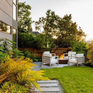 Foto di un piccolo patio o portico contemporaneo dietro casa con un focolare, pavimentazioni in cemento e nessuna copertura