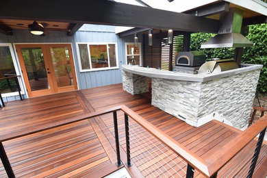 Mid-sized trendy backyard patio kitchen photo in Seattle with decking and a roof extension