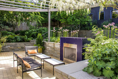 Diseño de patio moderno de tamaño medio en patio trasero con brasero, adoquines de hormigón y pérgola