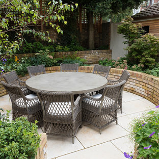 Design ideas for a medium sized traditional back patio in London with natural stone paving and no cover.