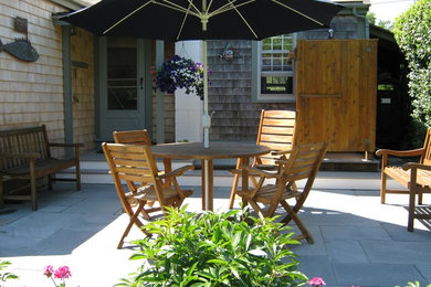Example of a backyard stone patio design in Manchester
