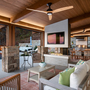 Esempio di un grande patio o portico minimalista dietro casa con un caminetto e un tetto a sbalzo