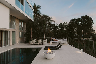Patio - mid-sized contemporary backyard stone patio idea in Los Angeles with a fire pit