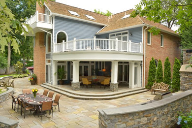 Large elegant backyard stone patio photo in Baltimore with a fire pit and a roof extension