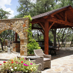 Foto di un grande patio o portico stile americano dietro casa con pavimentazioni in pietra naturale e un gazebo o capanno