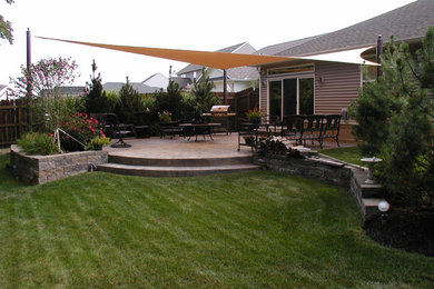 Patio kitchen - large traditional backyard concrete paver patio kitchen idea in Cleveland with an awning