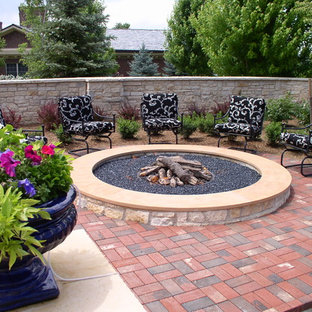 Aménagement d'une terrasse classique avec des pavés en brique et un foyer extérieur.