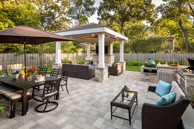 Ejemplo de patio clásico renovado en patio trasero con cocina exterior, adoquines de hormigón y cenador