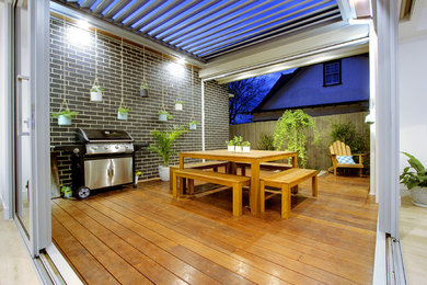 Medium sized contemporary courtyard patio in Melbourne with decking and a pergola.