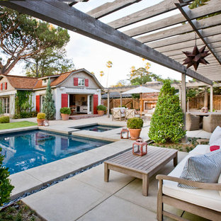 Idee per un patio o portico country dietro casa con lastre di cemento e una pergola