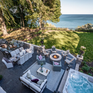 Immagine di un grande patio o portico chic dietro casa con pavimentazioni in cemento e nessuna copertura