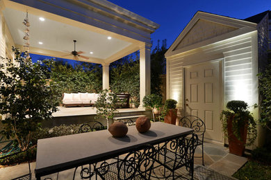 Patio - mid-sized traditional backyard stone patio idea in New Orleans with a roof extension
