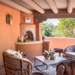 Esempio di un patio o portico american style di medie dimensioni e nel cortile laterale con un focolare, piastrelle e un tetto a sbalzo