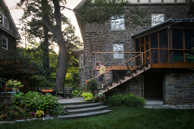 Idée de décoration pour une terrasse arrière avec un foyer extérieur, des pavés en pierre naturelle et aucune couverture.