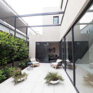 Inspiration for a mid-sized contemporary courtyard patio in Melbourne with no cover and tile.