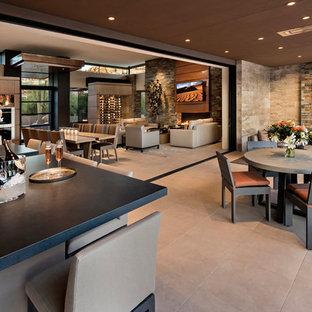 Immagine di un grande patio o portico american style con piastrelle, un tetto a sbalzo e un caminetto