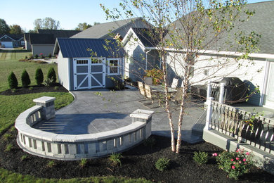Mid-sized elegant backyard concrete paver patio photo in Other with no cover