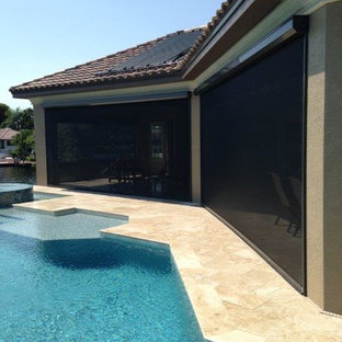 Idee per un patio o portico contemporaneo di medie dimensioni e dietro casa con piastrelle e un tetto a sbalzo