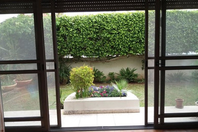 Modelo de patio clásico de tamaño medio sin cubierta en patio trasero con jardín de macetas y granito descompuesto