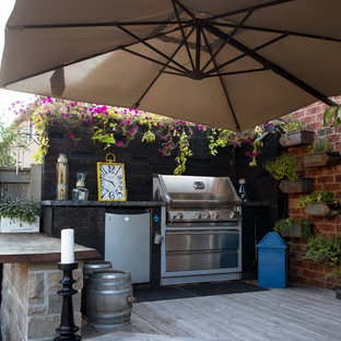 Immagine di un patio o portico stile americano di medie dimensioni e dietro casa con pedane e un parasole
