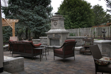 Large elegant backyard concrete paver patio photo in Omaha with a fire pit and no cover