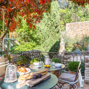 Cette image montre une terrasse avec des plantes en pots méditerranéenne de taille moyenne avec aucune couverture et du carrelage.