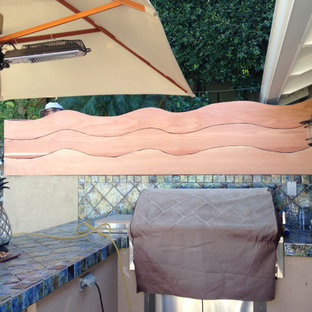 Foto di un patio o portico boho chic di medie dimensioni e dietro casa con un focolare e pavimentazioni in pietra naturale