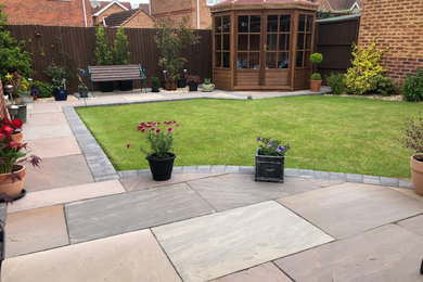 Small modern back patio in Other with natural stone paving.