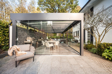 Inspiration for a large contemporary back patio in Hamburg with an outdoor kitchen, concrete paving and a gazebo.