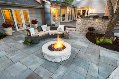 Inspiration for a mid-sized contemporary backyard concrete paver patio remodel in Chicago with a fire pit and no cover