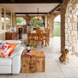 Idee per un grande patio o portico rustico dietro casa con pavimentazioni in pietra naturale e un tetto a sbalzo