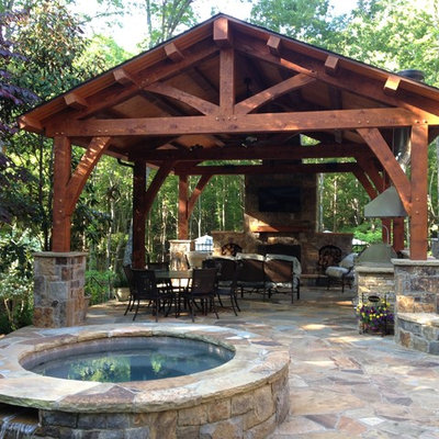 Inspiration for a mid-sized rustic backyard stone patio remodel in Charlotte with a gazebo