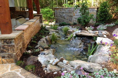 Example of a mid-sized mountain style backyard stone patio design in Charlotte with a fireplace and a gazebo