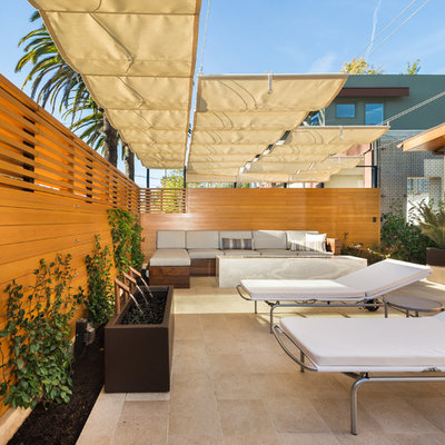 Inspiration for a mid-sized modern tile patio fountain remodel in Los Angeles with an awning