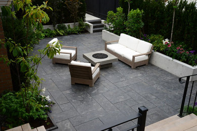 Inspiration for a small contemporary backyard stone patio remodel in Vancouver with a fire pit