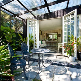 Esempio di un patio o portico eclettico di medie dimensioni e dietro casa con cemento stampato e una pergola
