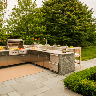 Patio kitchen - large traditional backyard concrete paver patio kitchen idea in New York with an awning