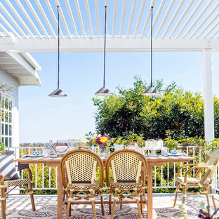 Foto di un piccolo patio o portico eclettico dietro casa con lastre di cemento e una pergola