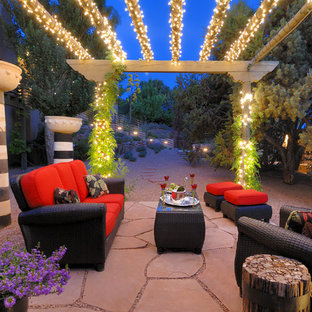 Idée de décoration pour une terrasse arrière sud-ouest américain de taille moyenne avec des pavés en pierre naturelle et une pergola.