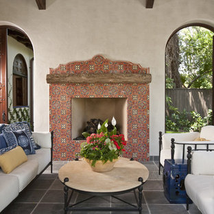 Foto di un patio o portico stile americano con un focolare e piastrelle