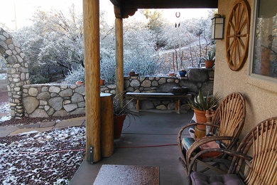 Inspiration for a mid-sized southwestern front yard concrete patio remodel in Phoenix with a roof extension