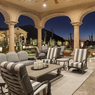 Immagine di un ampio patio o portico mediterraneo dietro casa con pavimentazioni in pietra naturale e un gazebo o capanno