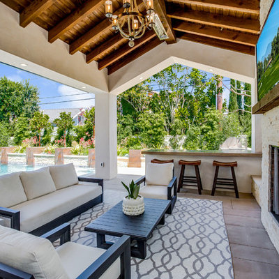 Patio - mediterranean patio idea in Orange County with a roof extension