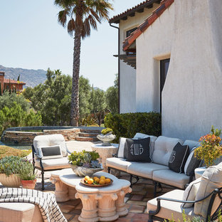 Esempio di un ampio patio o portico mediterraneo dietro casa con fontane, nessuna copertura e piastrelle