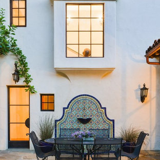 Large mediterranean back patio in Santa Barbara with natural stone paving and no cover.
