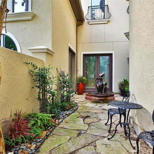 Esempio di un ampio patio o portico mediterraneo in cortile con fontane e pavimentazioni in pietra naturale