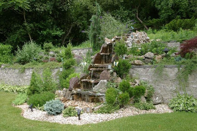 Inspiration for a large traditional backyard concrete paver water fountain landscape in New York.