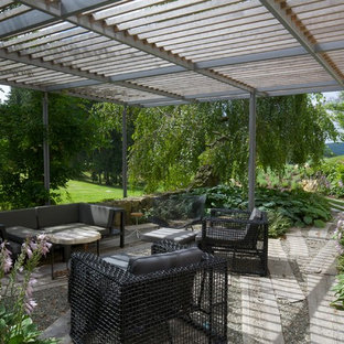 Foto di un grande patio o portico contemporaneo dietro casa con una pergola, fontane e ghiaia