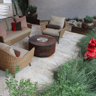 Ispirazione per un piccolo patio o portico moderno dietro casa con pavimentazioni in pietra naturale e un parasole